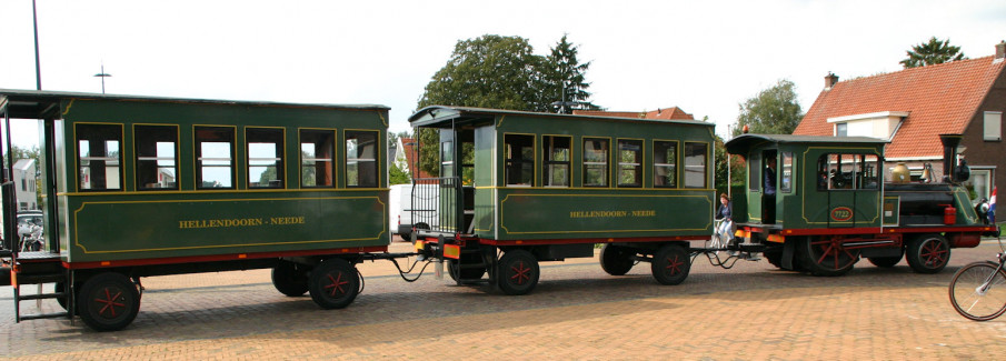 Oud aandoend treintje op luchtbanden. Groene wagonnen met locomotief.
